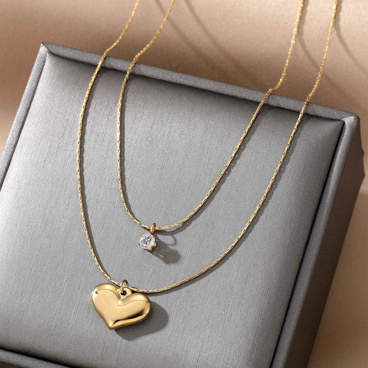 Gold-plated layered necklace with heart pendant and clear crystal accent